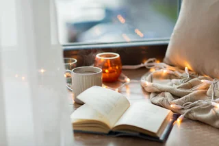 An open book and a cup of coffee in warm, cozy light
